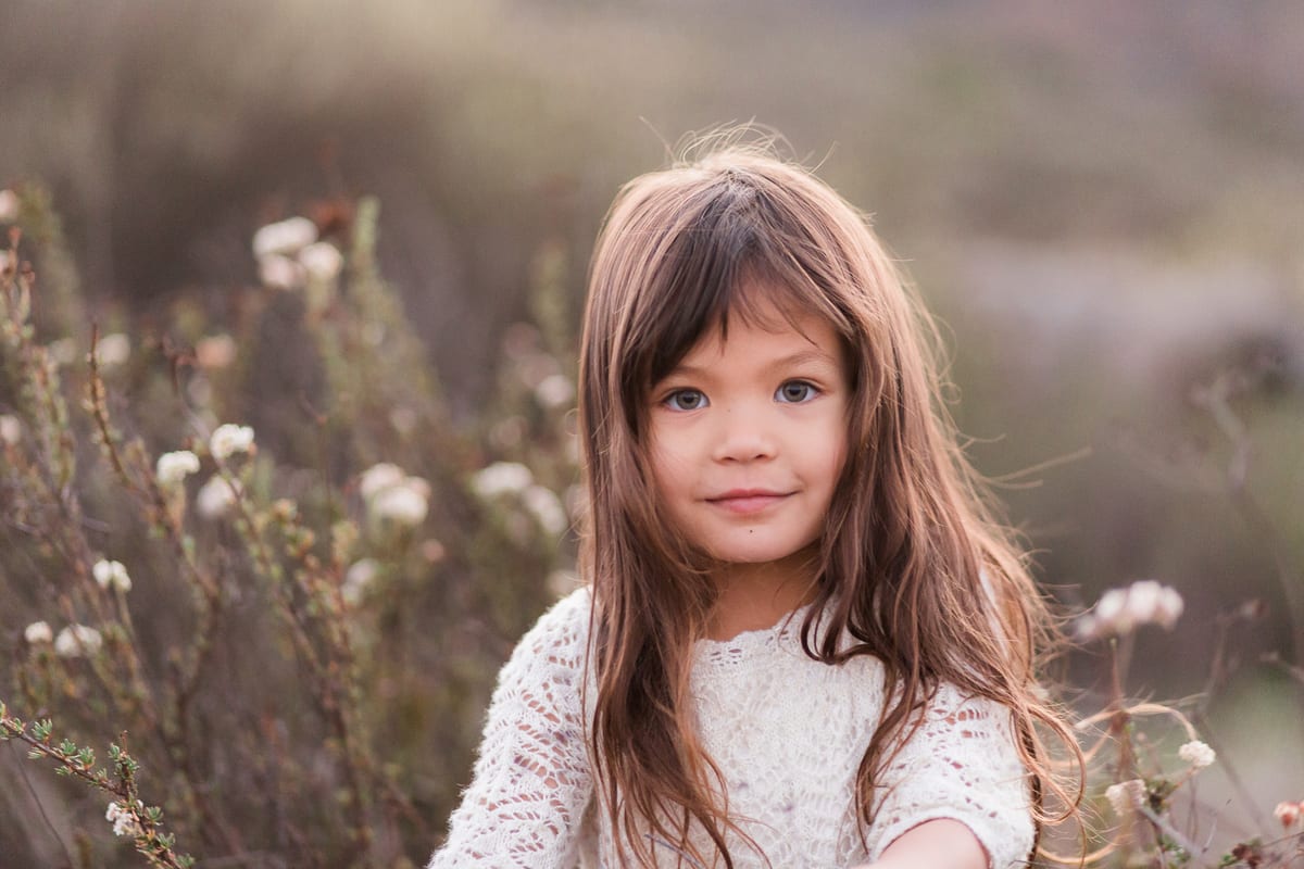 Portrait of a girl with long brown hair among dried wildflowers