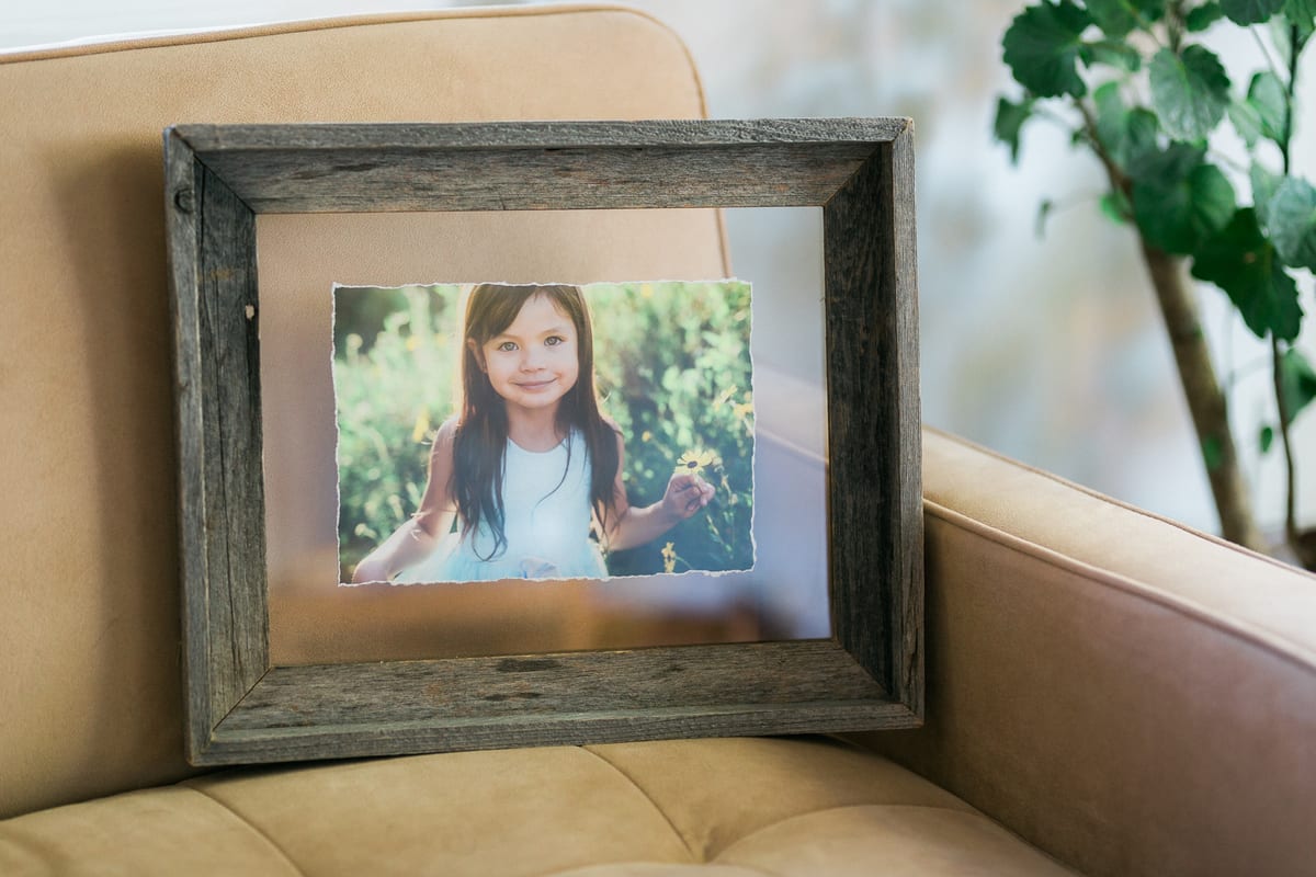 Rustic wood frame holding a portrait of a smiling girl