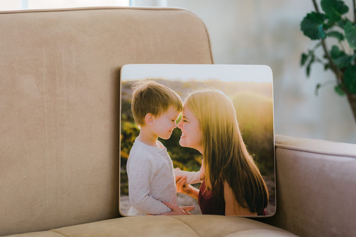 Mounted print of a mother and son touching noses resting on a sofa