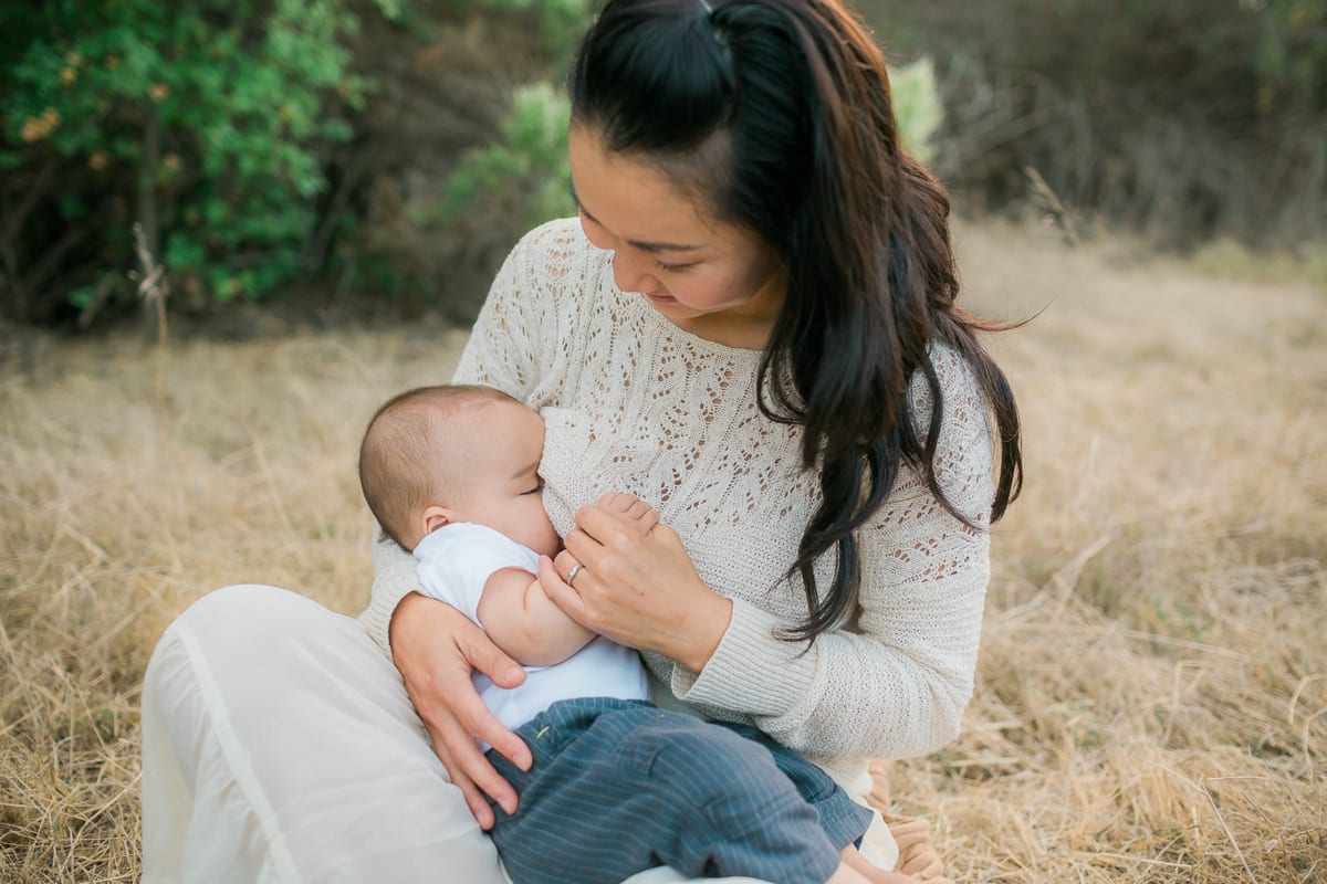 Mother nursing her baby in a golden field