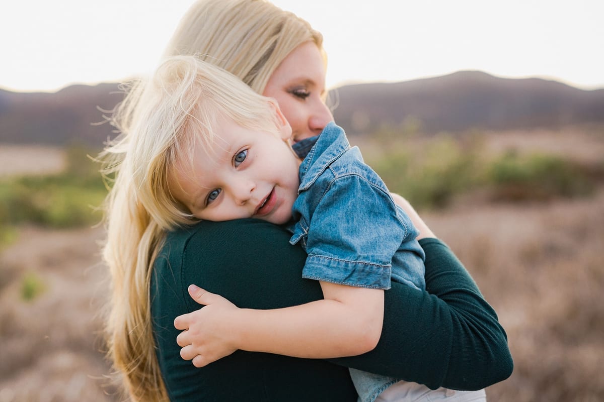 Little boy resting his head on his mother's shoulder