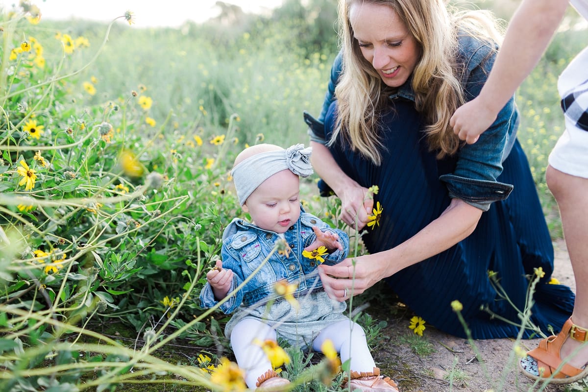 Mother handing a yellow wildflower to her baby