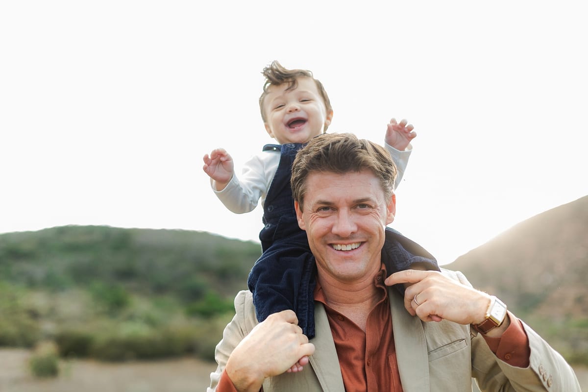 Father carrying his laughing baby on his shoulders
