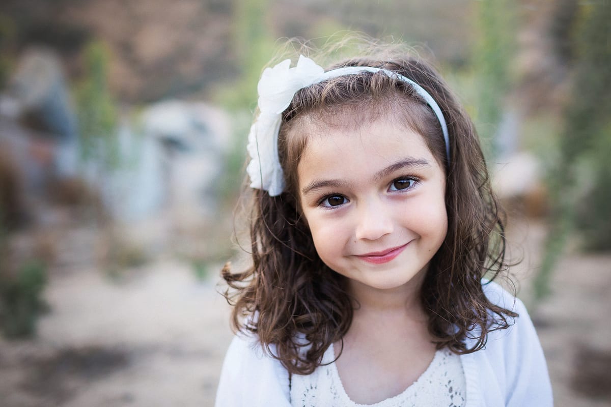 Smiling girl with a white bow headband