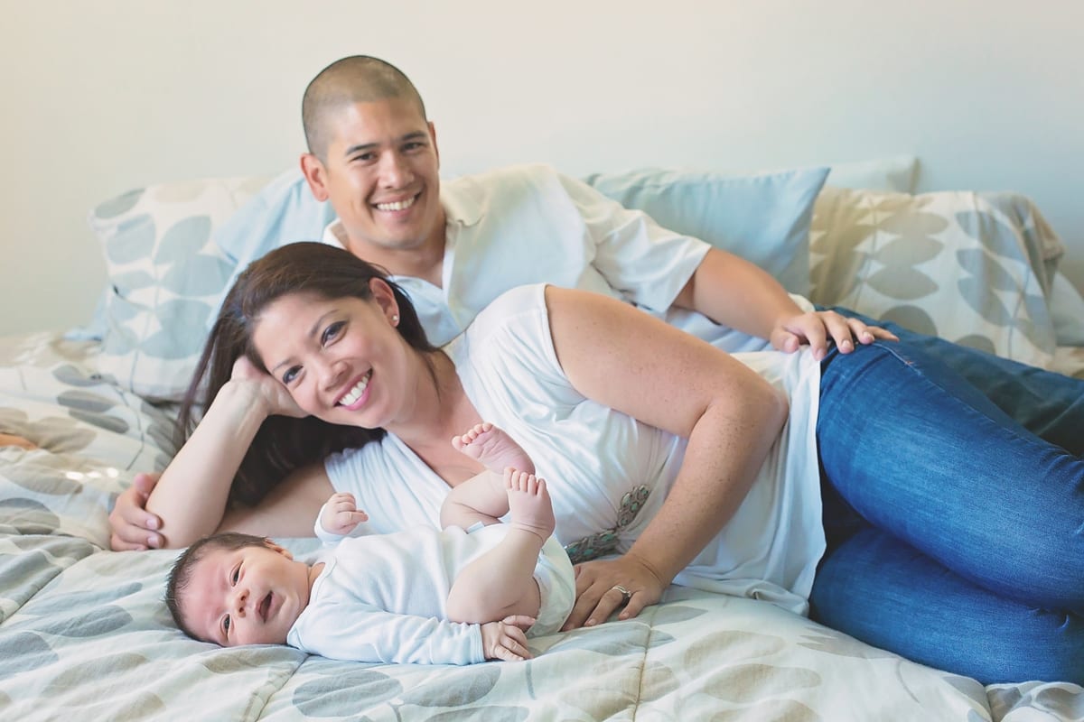Parents lying on the bed with their newborn