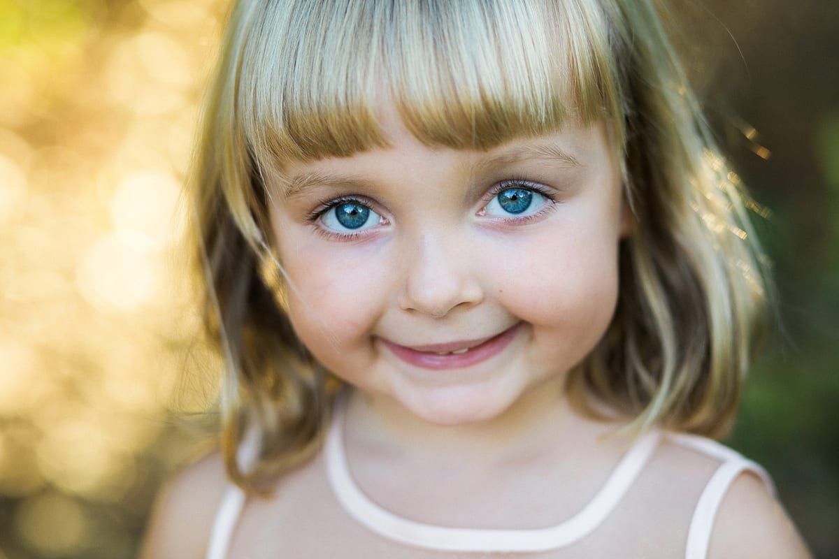 Close-up of a smiling blonde girl with bright blue eyes