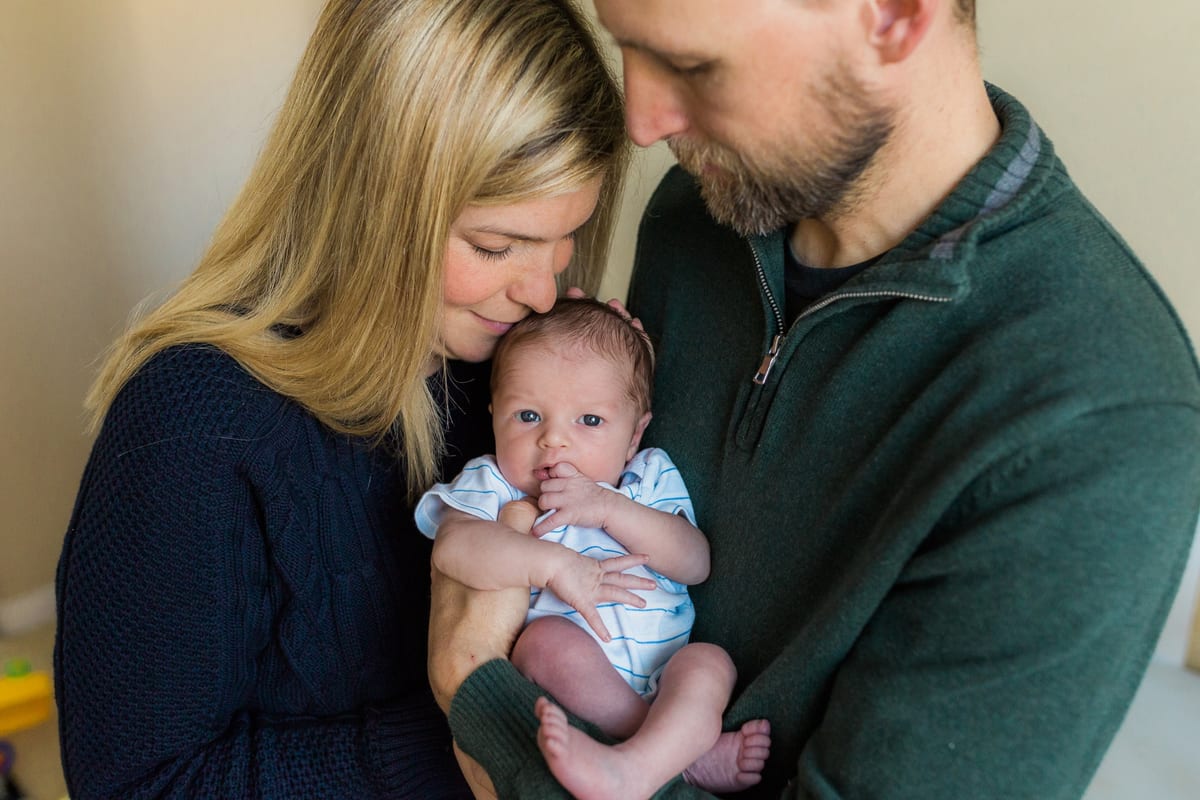 Parents cradling their newborn son between them
